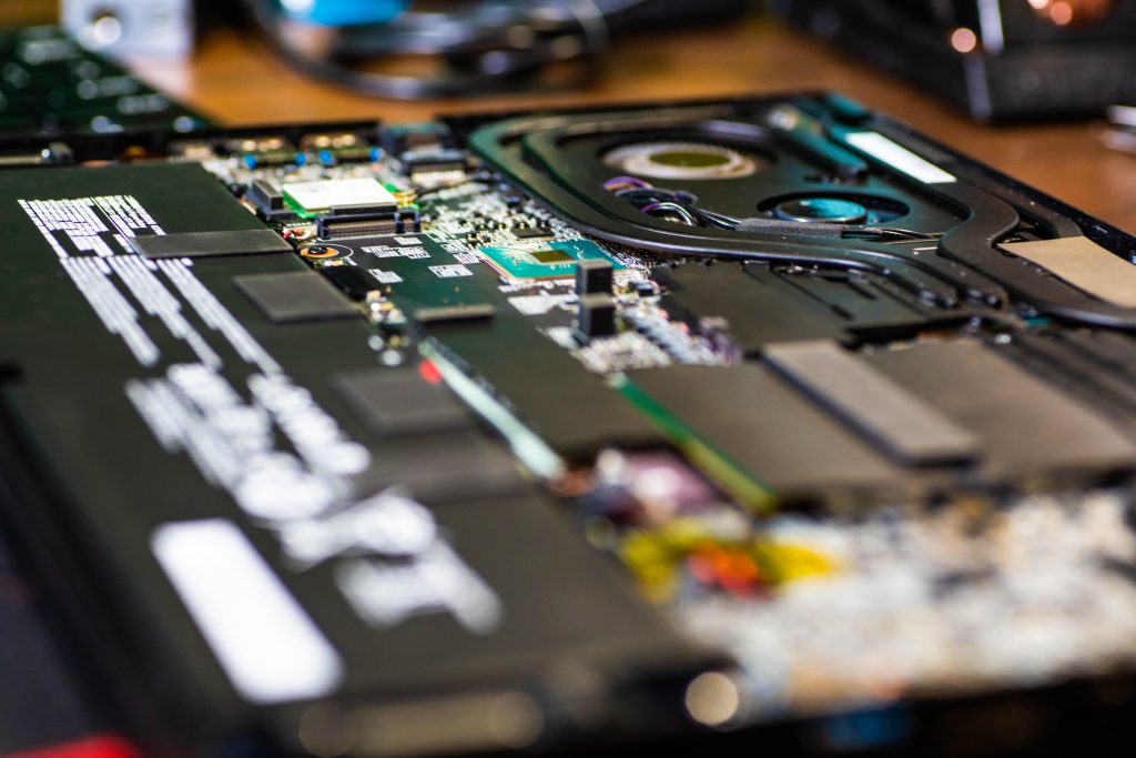 Inside a laptop showing cooling fans, heat pipes and motherboard